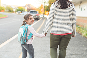 Mom walks her excited daughter to her first day of school
