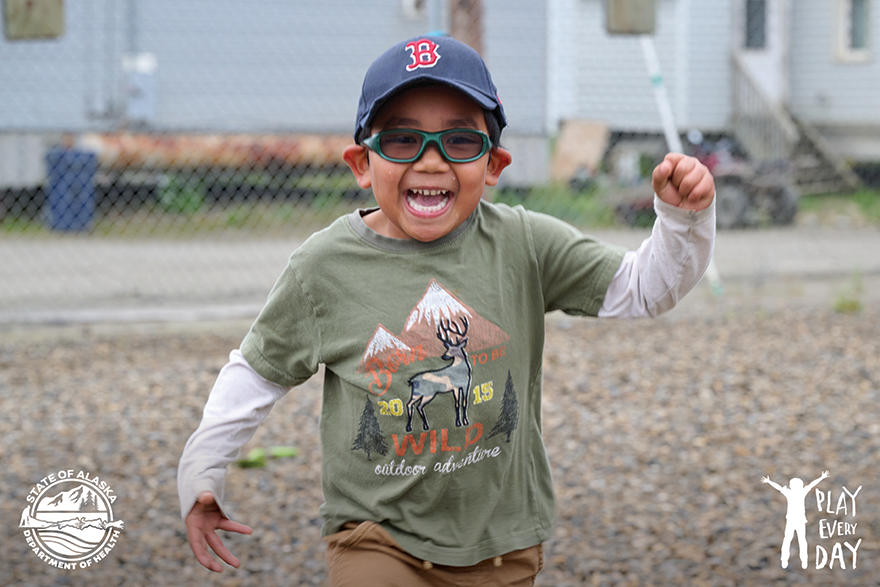 Preschool boy with glasses playing on the daycare playgroun.