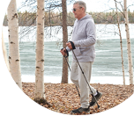 Alan walks using trekking poles for stability on a brisk winter day. He used the free call-in Inquisit Health program that's free for eligible Alaskans to lose 50 pounds.