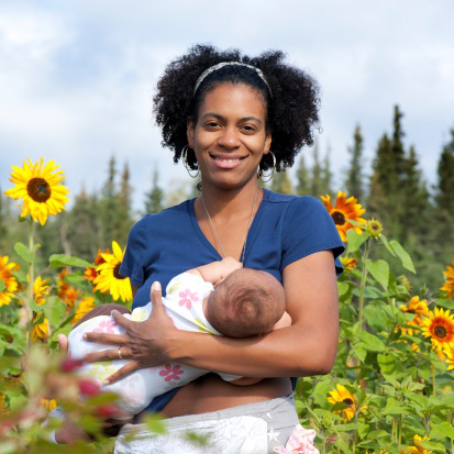 mom breastfeeding in sunflower field