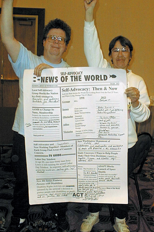 Photo of people holding large print of "Self-Advocacy News of the World"