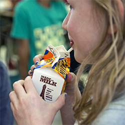 5th grade girl drinks milk with her health school lunch