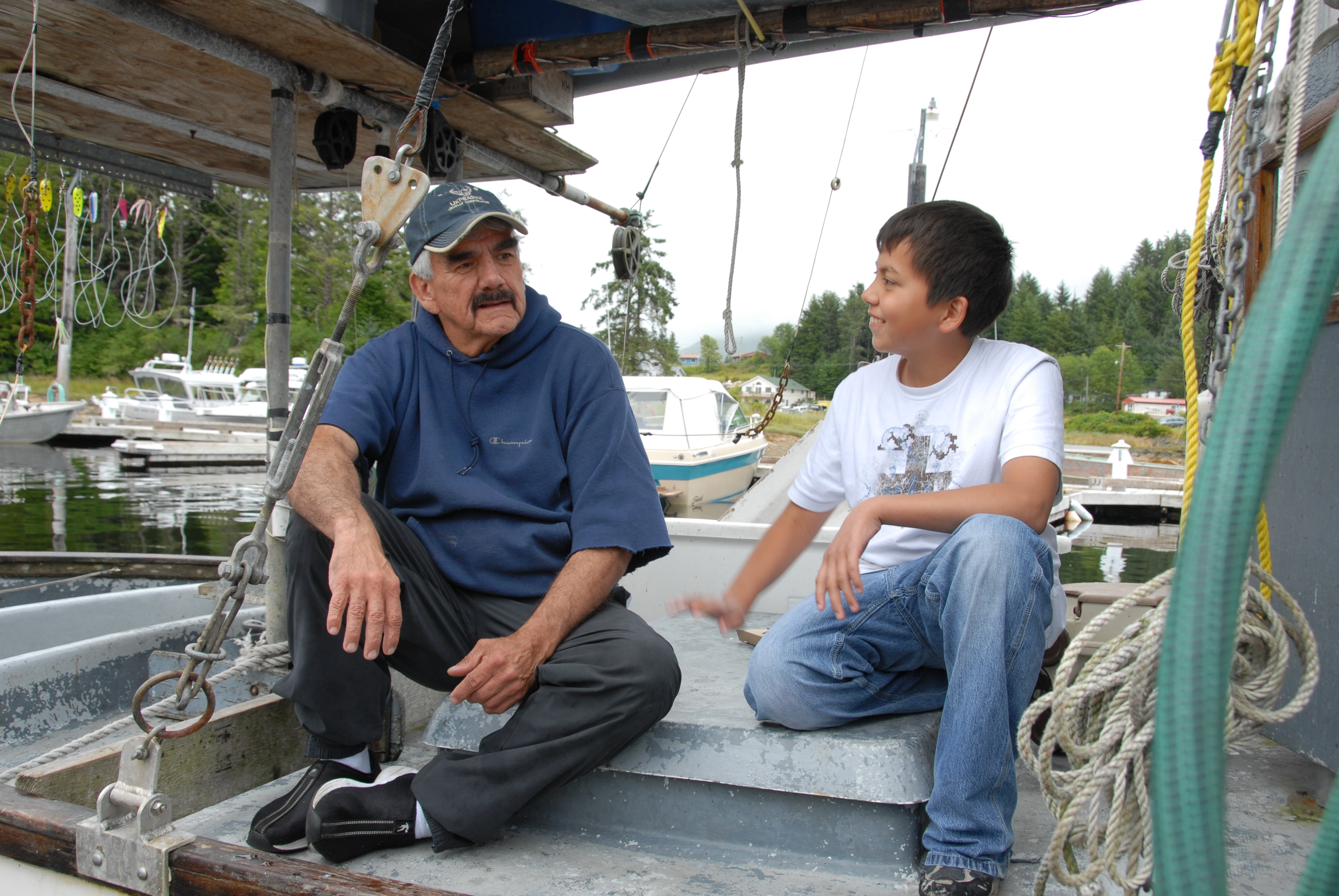 Man and boy sitting on a boat in a harbor